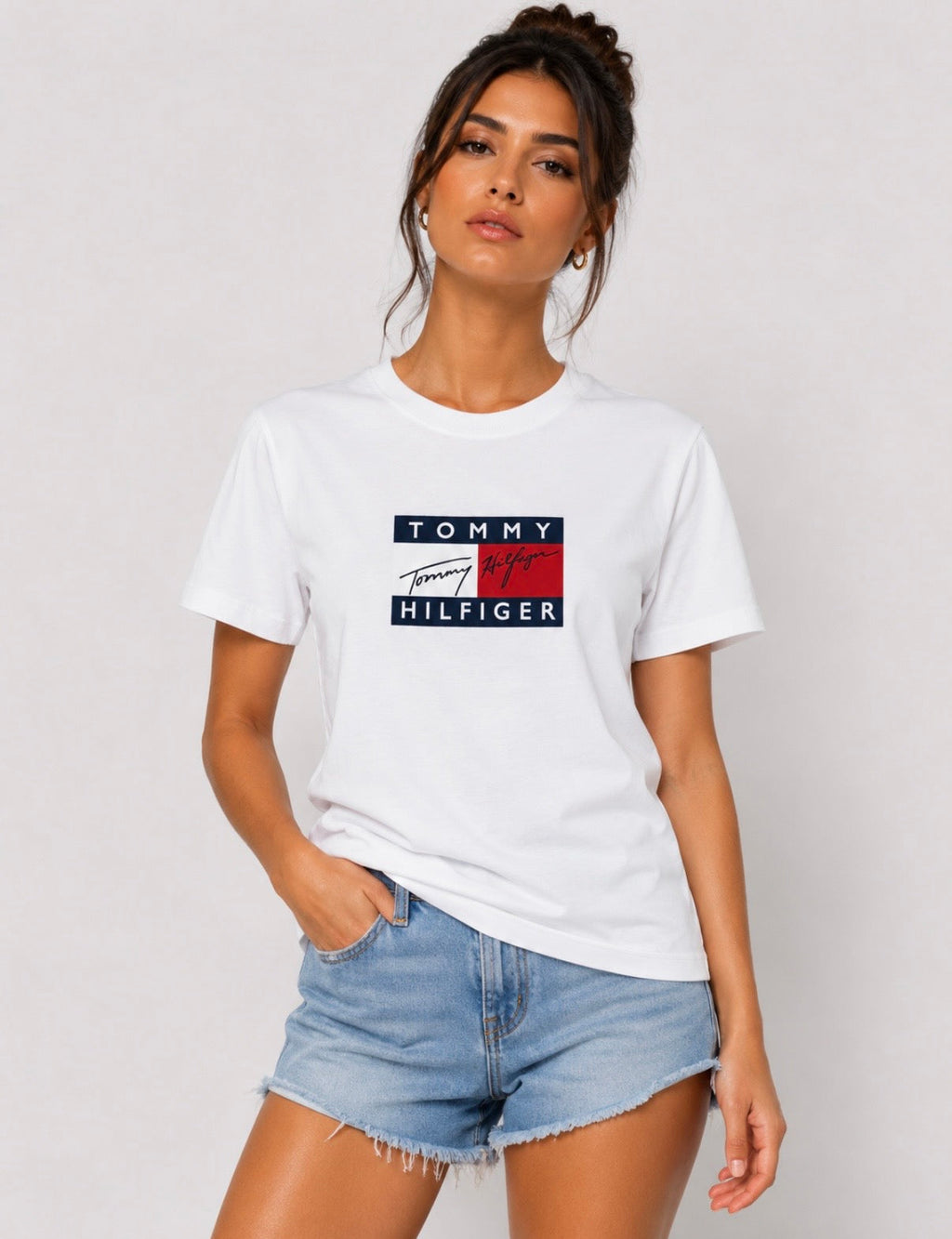 Detaliu logo Tommy Hilfiger pe tricou alb damă.