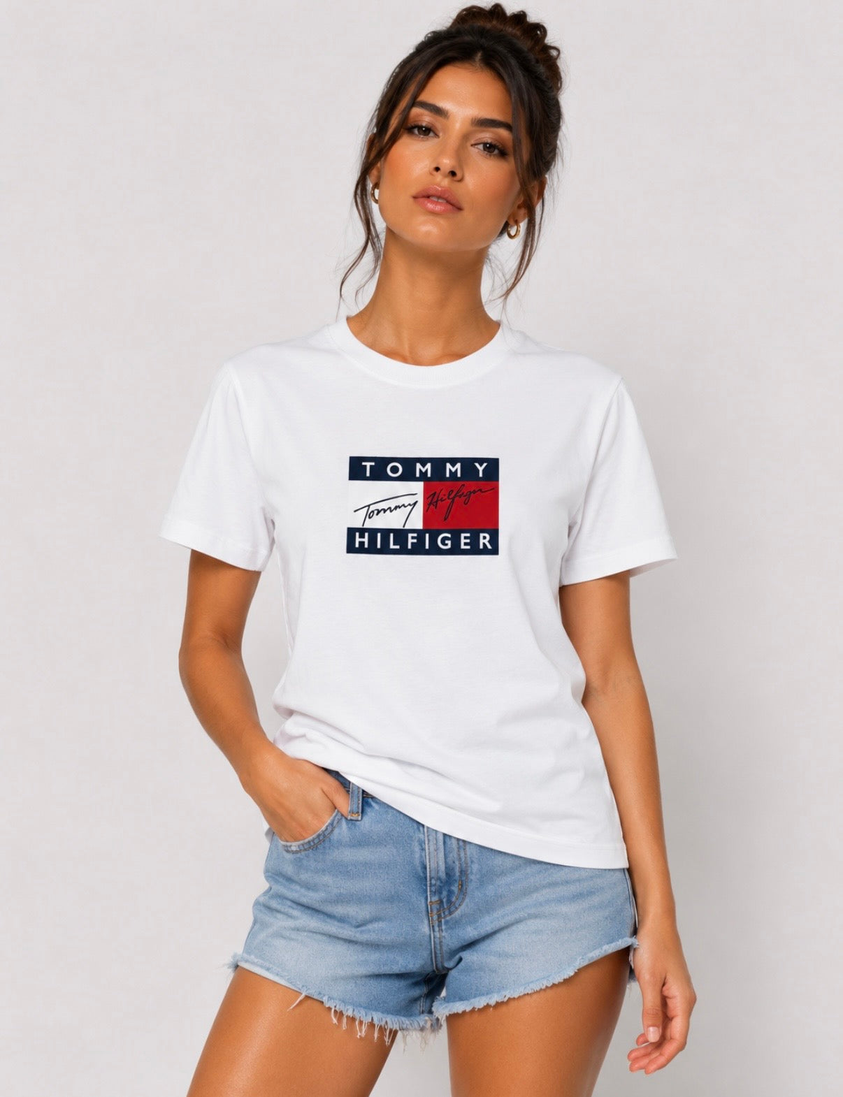 Detaliu logo Tommy Hilfiger pe tricou alb damă.